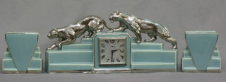 An Art Deco turquoise pottery 3 piece clock garniture with alarm clock 3 1/2" contained in a pottery case surmounted by 2 walking jaguars