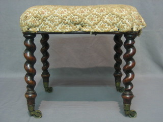 A Victorian square rosewood stool, raised on spiral turned supports ending in brass caps and castors 16"