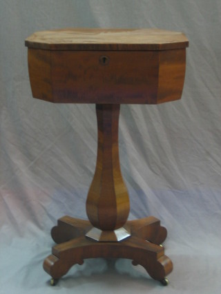 A Victorian lozenge shaped mahogany teapoy with hinged lid raised  on a baluster column with triform base 18"