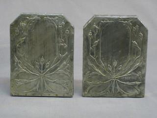 A pair of Art Nouveau embossed pewter bookends decorated stylised flowers 7"