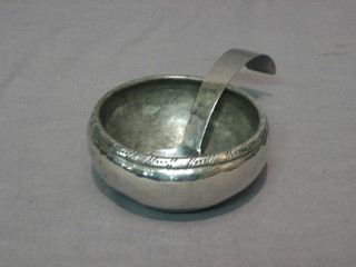 A circular planished pewter bowl the base signed HW 4" and a planished pewter spoon marked Kai Keswick