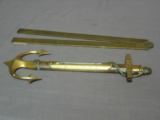 A brass thermometer in the form of an anchor and a brass rule