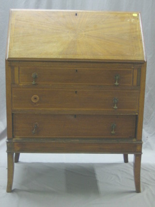 An Edwardian inlaid mahogany bureau, the fall front revealing a well fitted interior above 3 long graduated drawers, raised on splayed feet 30"