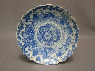 A Japanese blue and white circular porcelain plate decorated figures and with lobed body 9"