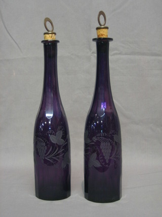2 19th Century purple etched glass club shaped wine bottles with vinery decoration, the brass and cork stoppers marked sherry and port (1 with slight chip to the base) 12"