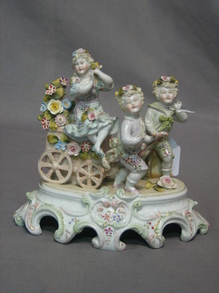 A Continental porcelain ornament in the form of cherubs pulling a hand cart, 9"