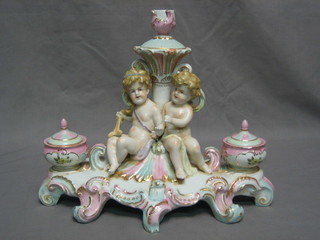 A reproduction 19th Century porcelain ink well supported by 2 cherubs 13"
