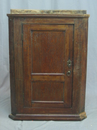An 18th/19th Century oak corner cabinet enclosed by a panelled door 27"