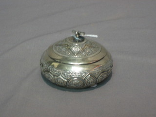 An Eastern embossed circular silver jar and cover, the lid decorated a dove, 3", 2 ozs