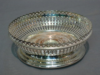 A circular pierced silver plated bottle coaster 6"