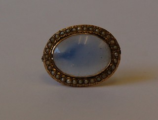 A 19th Century gilt metal brooch set an  oval blue hardstone surrounded by demi-pearls