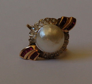 A lady's Art Deco style gold dress ring set a cabouchon cut pearl surrounded by 14 diamonds and 10 square cut rubies