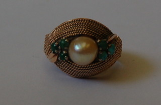 A gold dress ring set a pearl supported by 3 turquoise