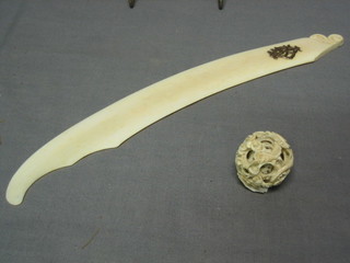 An ivory paper knife with "gold" monogramme 13" and a carved ivory puzzle ball 1"