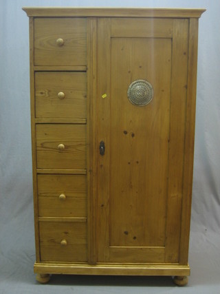 A Continental pine combination cabinet, the interior fitted shelves enclosed by a panelled door flanked by 5 drawers 37"