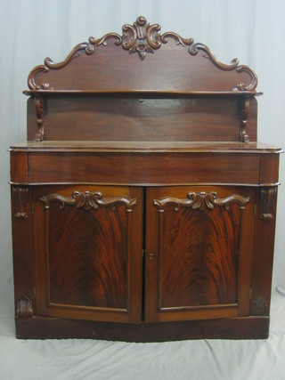 A Victorian mahogany chiffonier with raised back, the base of serpentine outline fitted 1 long drawer above a double cupboard, enclosed by panelled doors and raised on a platform base 47"