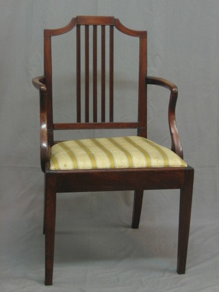 A 19th Century mahogany stick and rail back open arm carver chair with upholstered drop in seat, raised on square tapering supports