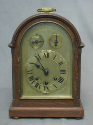 An  Edwardian chiming bracket clock with 6" arched silvered dial and Roman numerals, having a silent/strike indicator, contained in an oak case