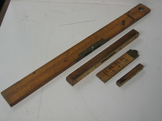 A wooden 24" ruler by J Rabone & Sons incorporating a spirit level, a folding wooden 24" gauge by Rabone, a brass and oak spirit level by Hockley Abbey 11" and a small ditto 4"