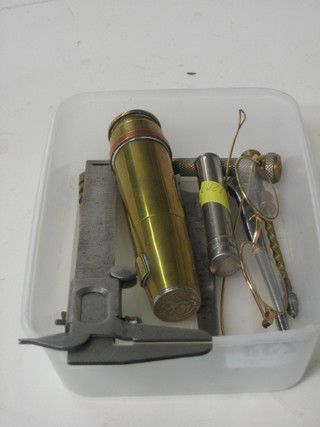A polished steel machine made box spanner 4", 1 other steel spanner 5", a brass glass cutter, a micrometer, 2 screw drivers, an old pair of spectacles, a shell lighter in the form of a shell and a small phial of gas mask cleaner