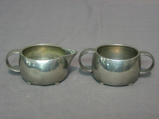 A Liberty's English  oval planished pewter twin handled sugar bowl with matching cream jug, base marked Liberty & Co Made in England 01535