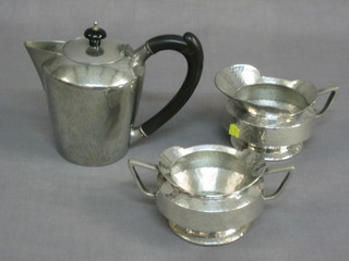 A Liberty & Co planished pewter hotwater jug with ebony handle, base marked English pewter Liberty & Co 01537 5", an Art Nouveau twin handled sugar bowl and matching cream jug, the base marked hammered pewter A1836B