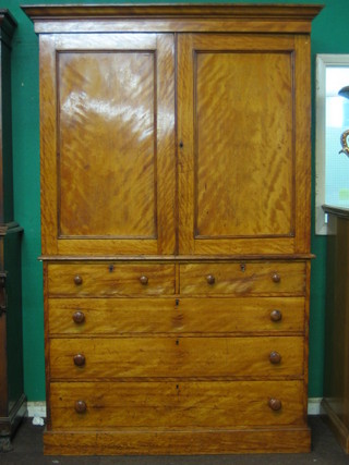 A Victorian satinwood linen press, the upper section with moulded cornice, the interior fitted 3 shelves enclosed by panelled doors, the base fitted 2 short and 3 long drawers, raised on a platform base, 52"