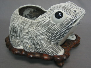 An Oriental white glazed porcelain figure of a seated toad raised on a hardwood stand 10"