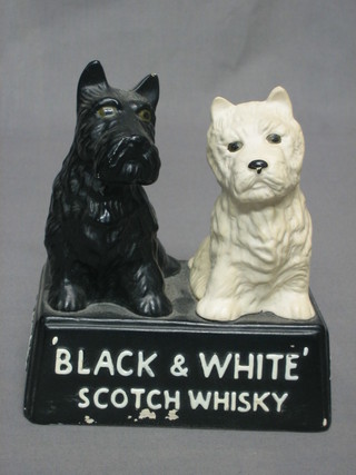 A pottery black and white Scots Whisky bar ornament, the base marked J G & M, 7"