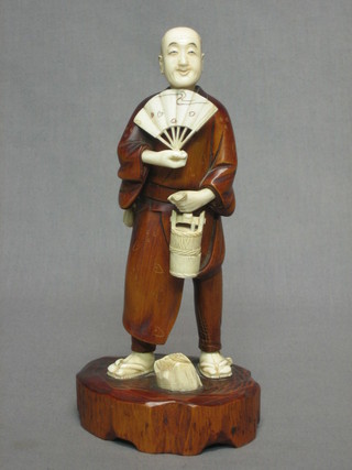 A Japanese carved hardwood and ivory figure of standing gentleman with fan and bucket the base with seal mark 9"