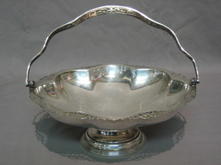 A circular pierced silver plated cake basket with swing handle 9 1/2"
