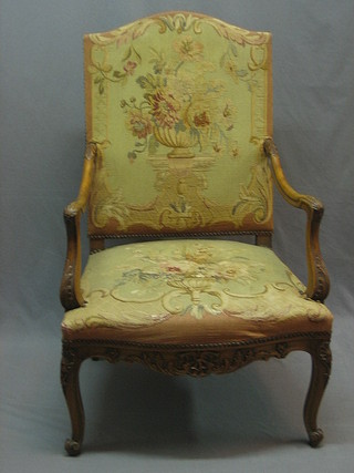 A 19th/20th Century Italian walnut carved open arm chair with upholstered seat and back, raised on cabriole supports