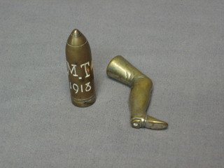 A gilt metal pipe tamper in the form of a gentleman's leg together with a bullets head marked MT 1918 (2)