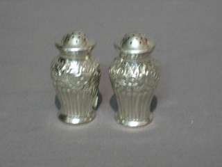 A pair of Victorian embossed silver pepperettes, Birmingham 1899 (marks rubbed), 1 ozs