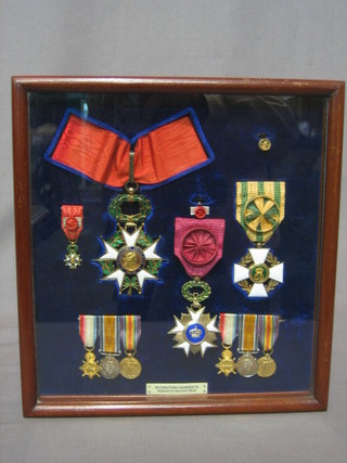 The Orders of Roderick Mackay Peat comprising The French Legion of Honour, Belgian Order of The Crown and The Luxemburg Order of The Oak Oak Crown, together with 2 groups of miniature medals 1914-15 Star, British War medal and Victory, all mounted in one framed by Spinks