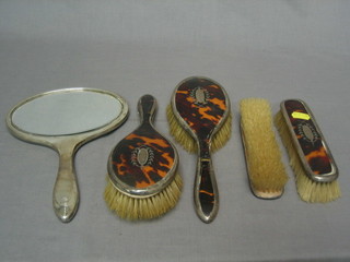 A 5 piece silver and tortoiseshell backed dressing table set comprising a pair of clothes brushes and a pair of hair brushes (1f) and a hand mirror, Birmingham 1927