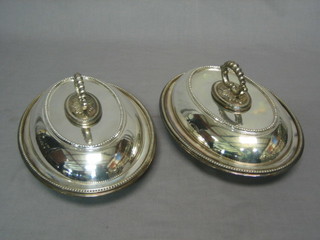 A pair of oval silver plated entree dishes and covers with bead work borders