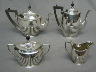 A Britannia metal 4 piece tea service comprising teapot, hotwater jug, twin handled sugar bowl and cover, together with a pair of silver plated sugar tongs and 3 teaspoons