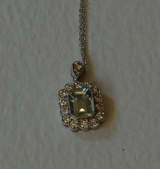 A lady's gold pendant set a rectangular cut aquamarine surrounded by numerous diamonds