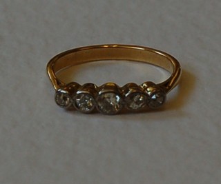 A lady's gold dress ring set 5 circular cut diamonds