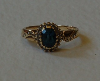 A 9ct gold dress ring set an oval cut Topaz surrounded by diamonds