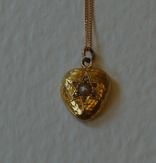 An 18ct gold heart shaped pendant set a demi-pearl and diamonds hung on a fine gold chain