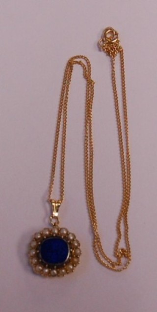 A lapis lazuli pendant surrounded by demi-pearls hung on a gold chain