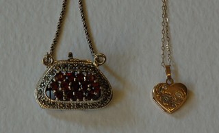 A 9ct gold heart shaped locket together with a "silver" pendant in the form of a purse set red stones, hung on a fine "silver" chain