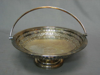 A circular silver plated cake basket with swing handle 9"