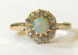 A lady's 18ct gold dress ring set an opal surrounded by 11 diamonds