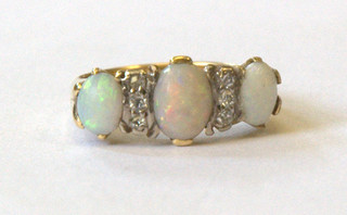 A lady's 9ct gold dress ring set 3 oval cut opals supported by 6 diamonds