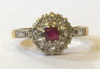 A lady's 18ct gold dress ring set a ruby surrounded by diamonds