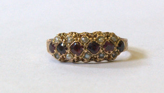 A lady's 15ct gold dress ring set 6 red coloured stones supported by demi-pearls