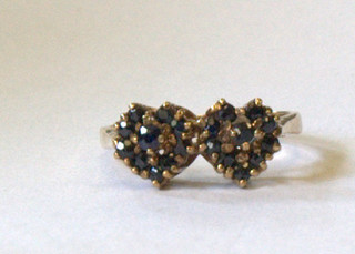 A 9ct gold dress ring in the form of 2 entwined hearts set sapphires